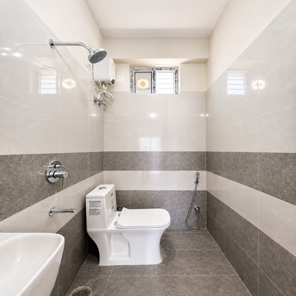 Modern bathroom, luxury bathroom, contemporary bathroom, stylish bathroom interior, premium bathroom design, elegant washroom, modern washroom, sophisticated bathroom, minimalist bathroom, clean bathroom interior, residential bathroom, compact bathroom, spacious washroom, ceramic wall tiles, grey bathroom tiles, white bathroom tiles, dual-tone tiles, patterned bathroom tiles, tiled flooring, modern toilet, western toilet, wall mounted shower, overhead shower, bathroom hand shower, chrome bathroom fittings, bathroom fixtures, modern sanitaryware, ceramic wash basin, bathroom sink, sleek wash basin, bathroom plumbing, bathroom accessories, bathroom window, ventilated bathroom, natural light bathroom, bright bathroom interior, neutral bathroom decor, grey and white bathroom, contemporary home bathroom, apartment bathroom, functional bathroom, neat washroom, hygienic bathroom, modern home interior, designer bathroom, elegant sanitary fittings, bathroom renovation, modern bathing area, luxury washroom interior, aesthetic bathroom, clean modern washroom